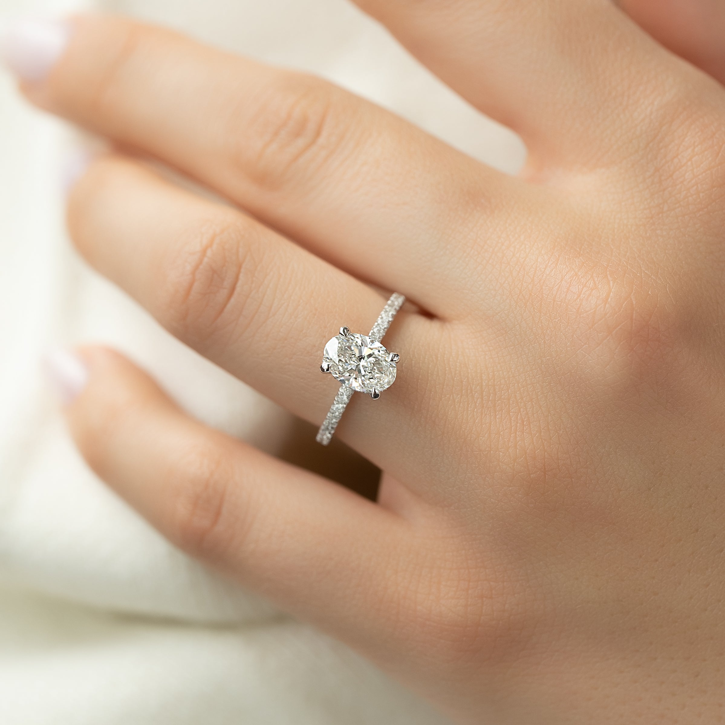 Oval cut CVD diamond engagement ring featuring hidden halo and pave band in platinum