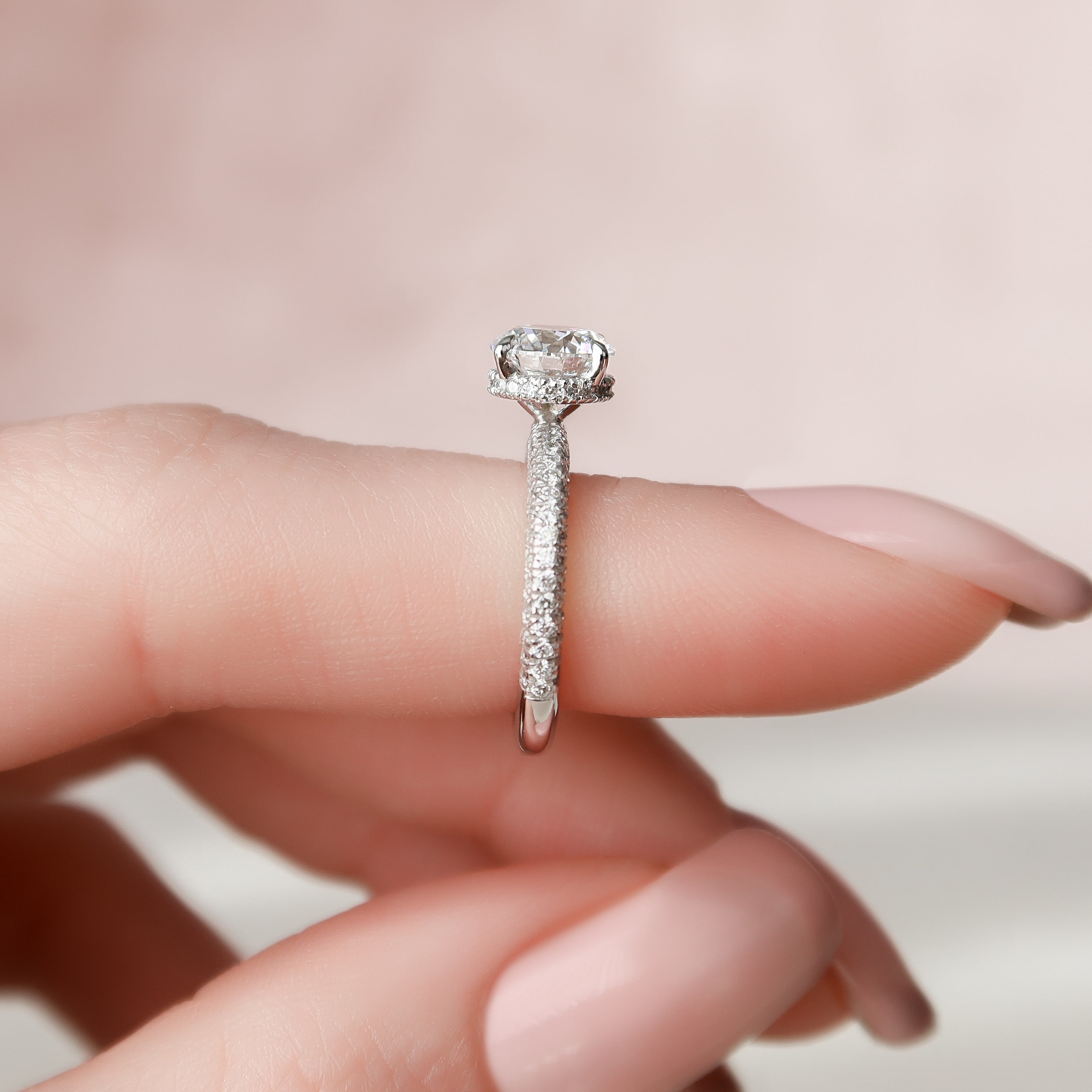 Round cut moissanite engagement ring with hidden halo and pave band in white gold setting