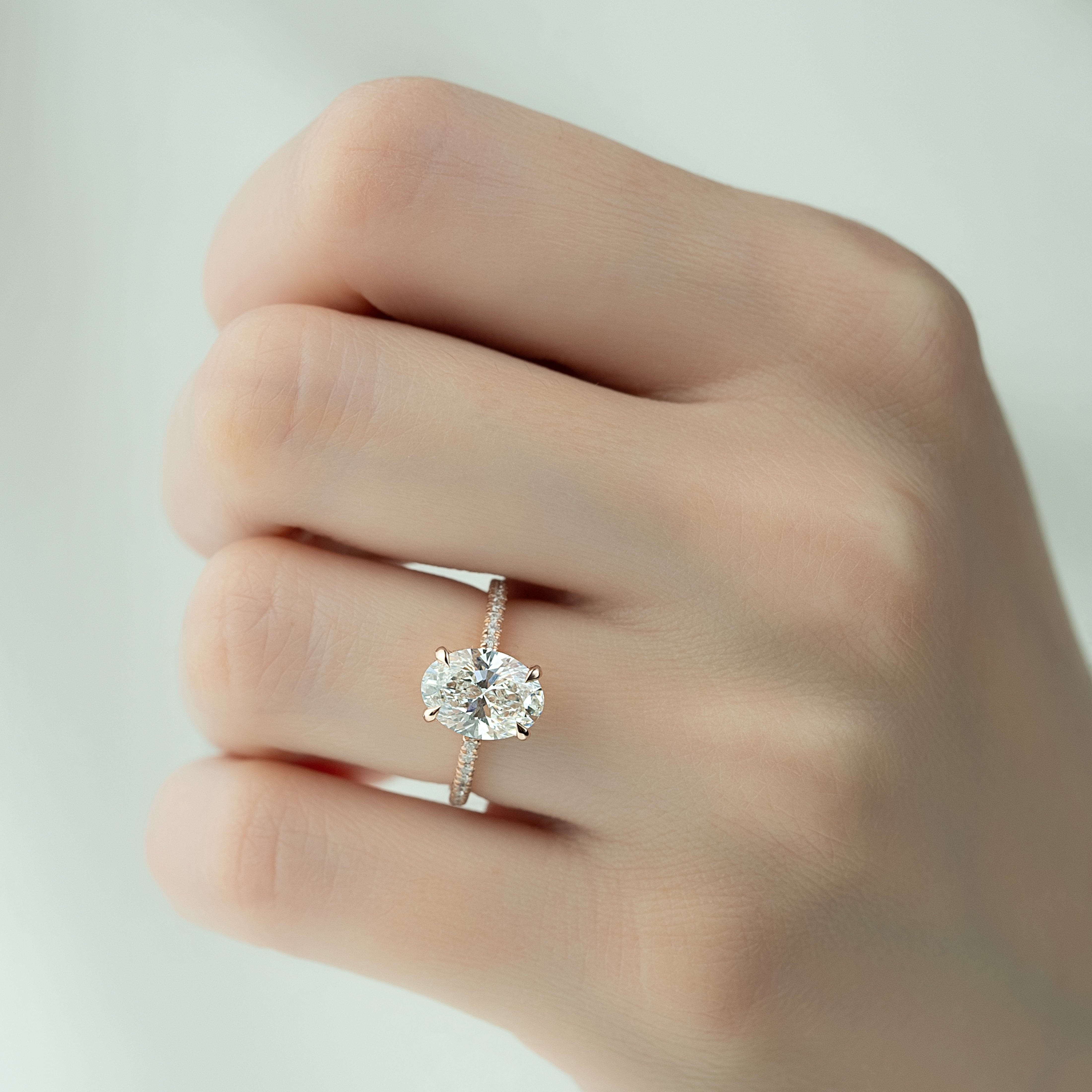 Oval cut CVD diamond engagement ring featuring hidden halo and pave band in platinum