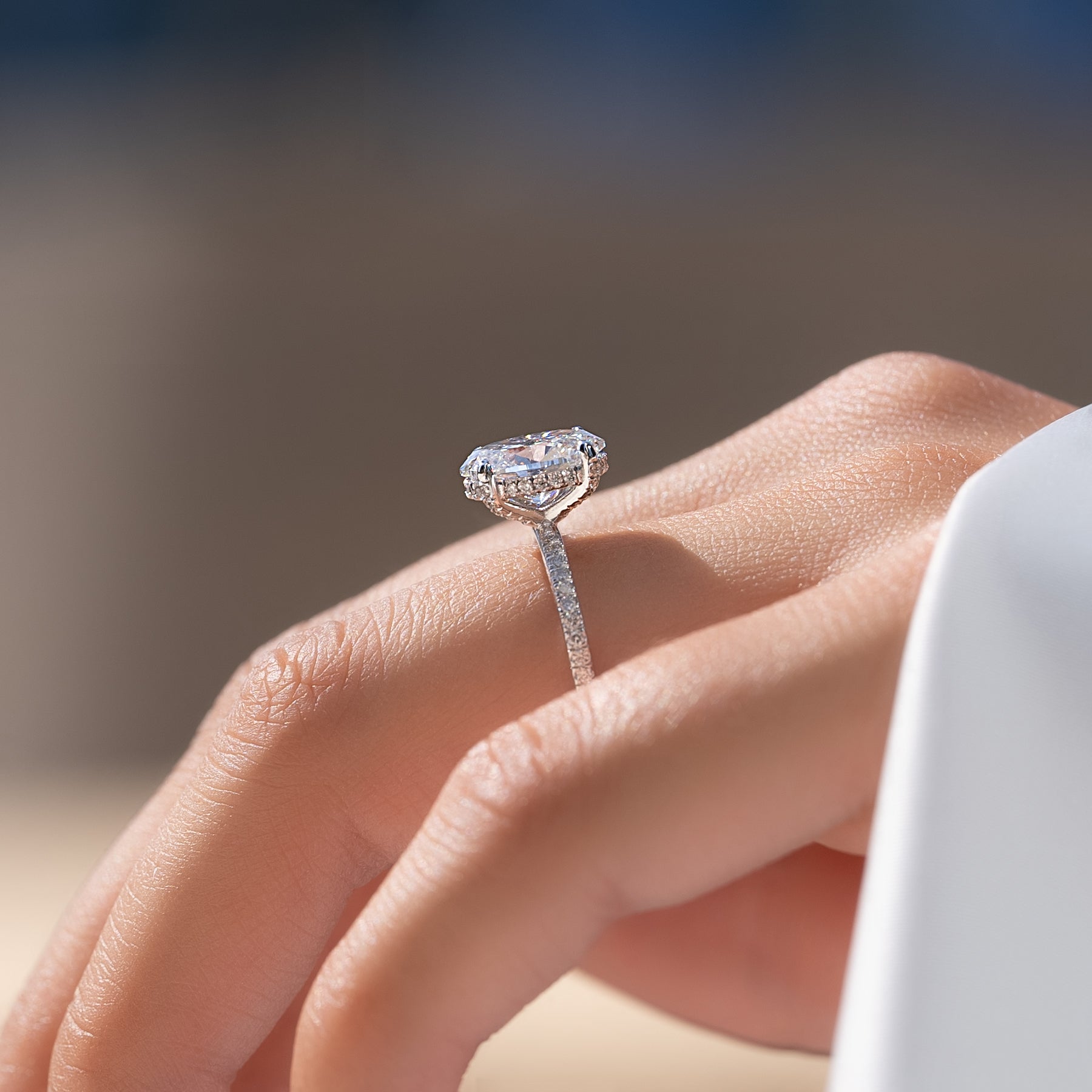 Oval cut CVD diamond engagement ring featuring hidden halo and pave band in platinum