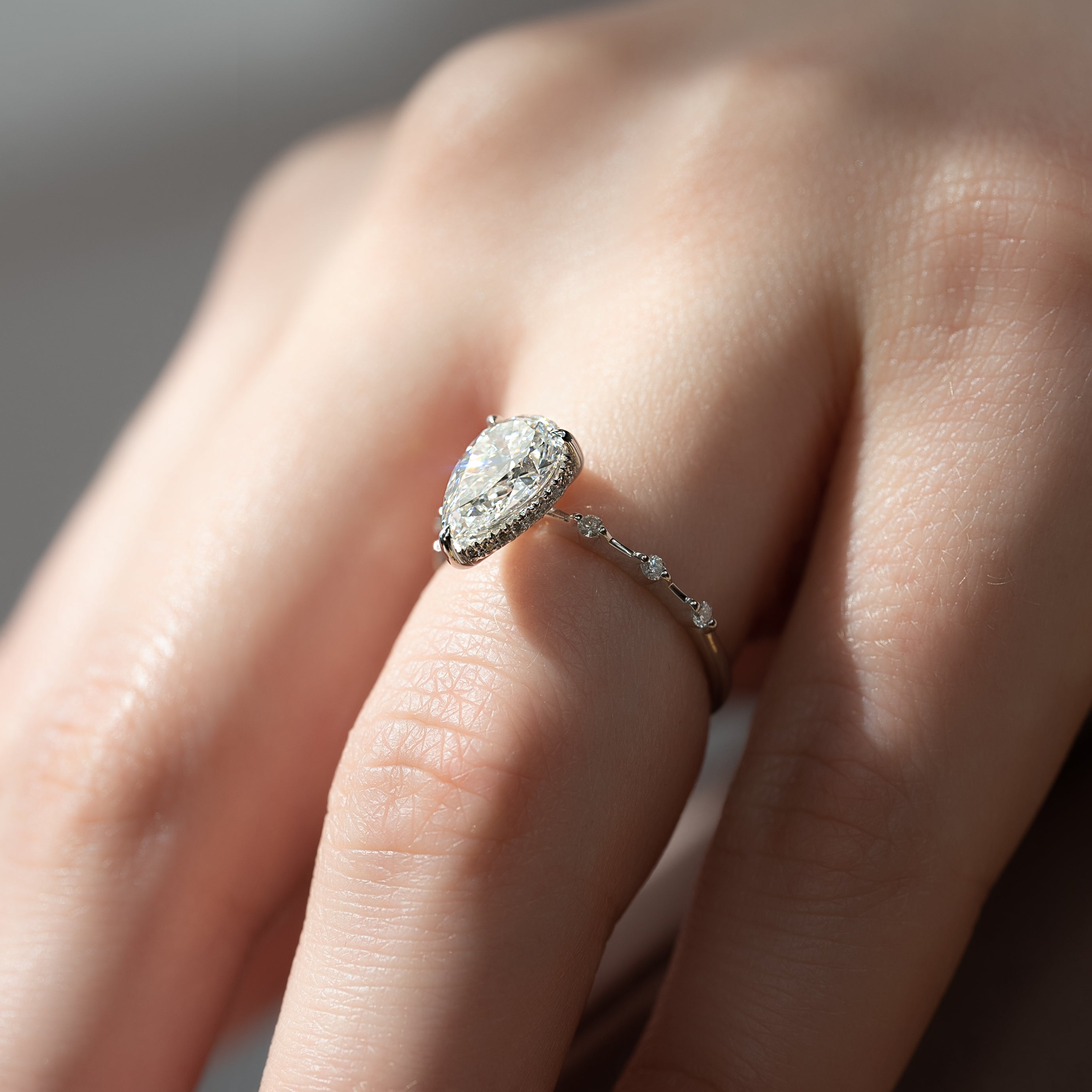 Pear cut CVD diamond engagement ring with hidden halo and dainty pave band in white gold