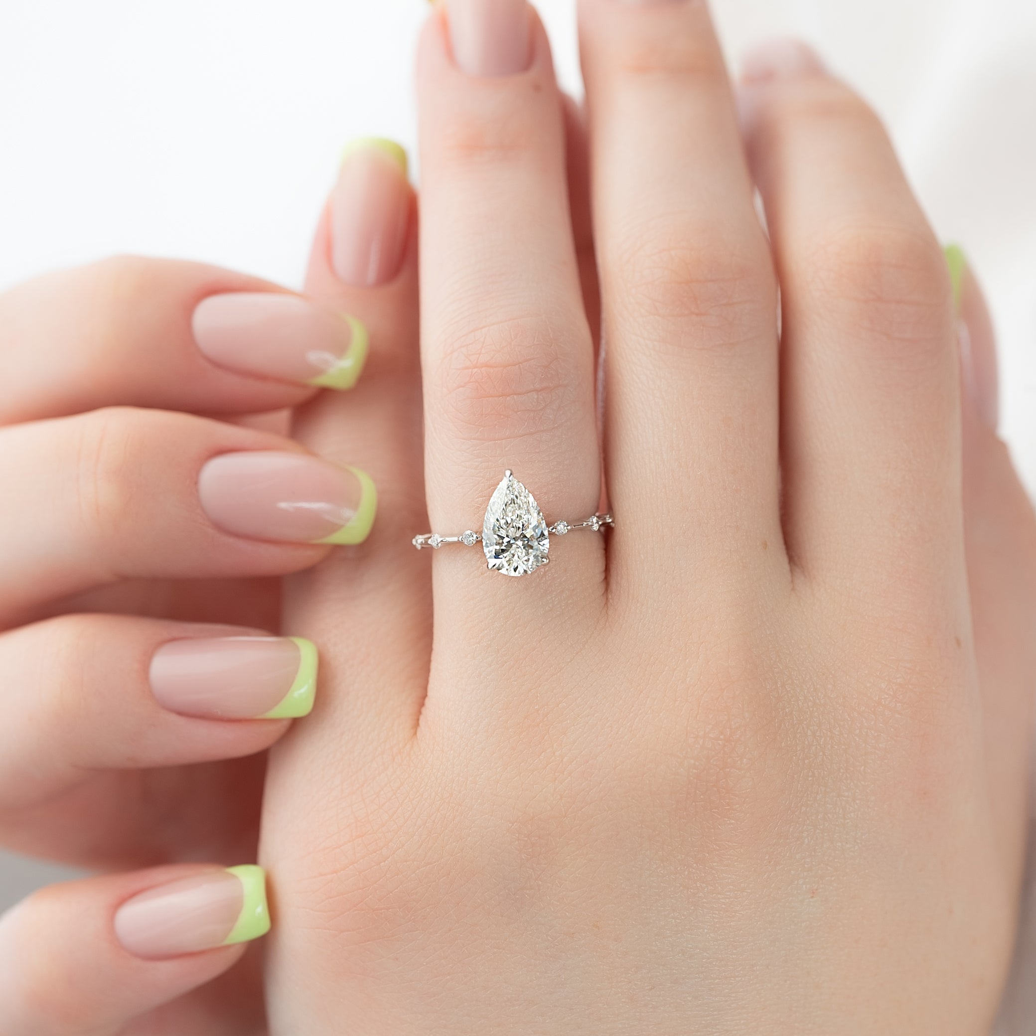 Pear cut CVD diamond engagement ring with hidden halo and dainty pave band in white gold