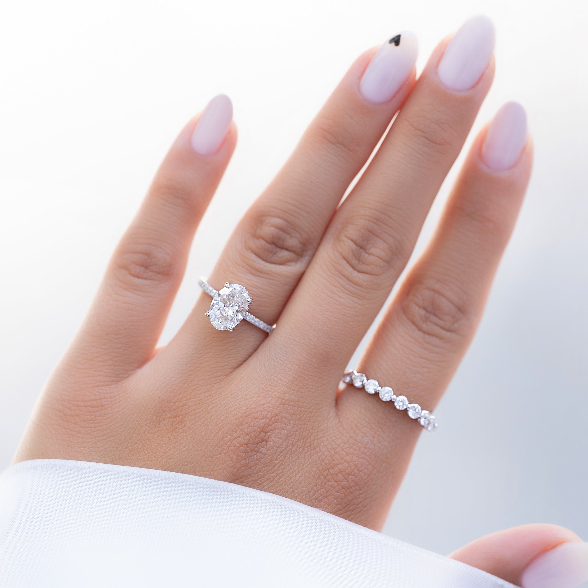 Oval cut CVD diamond engagement ring featuring hidden halo and pave band in platinum