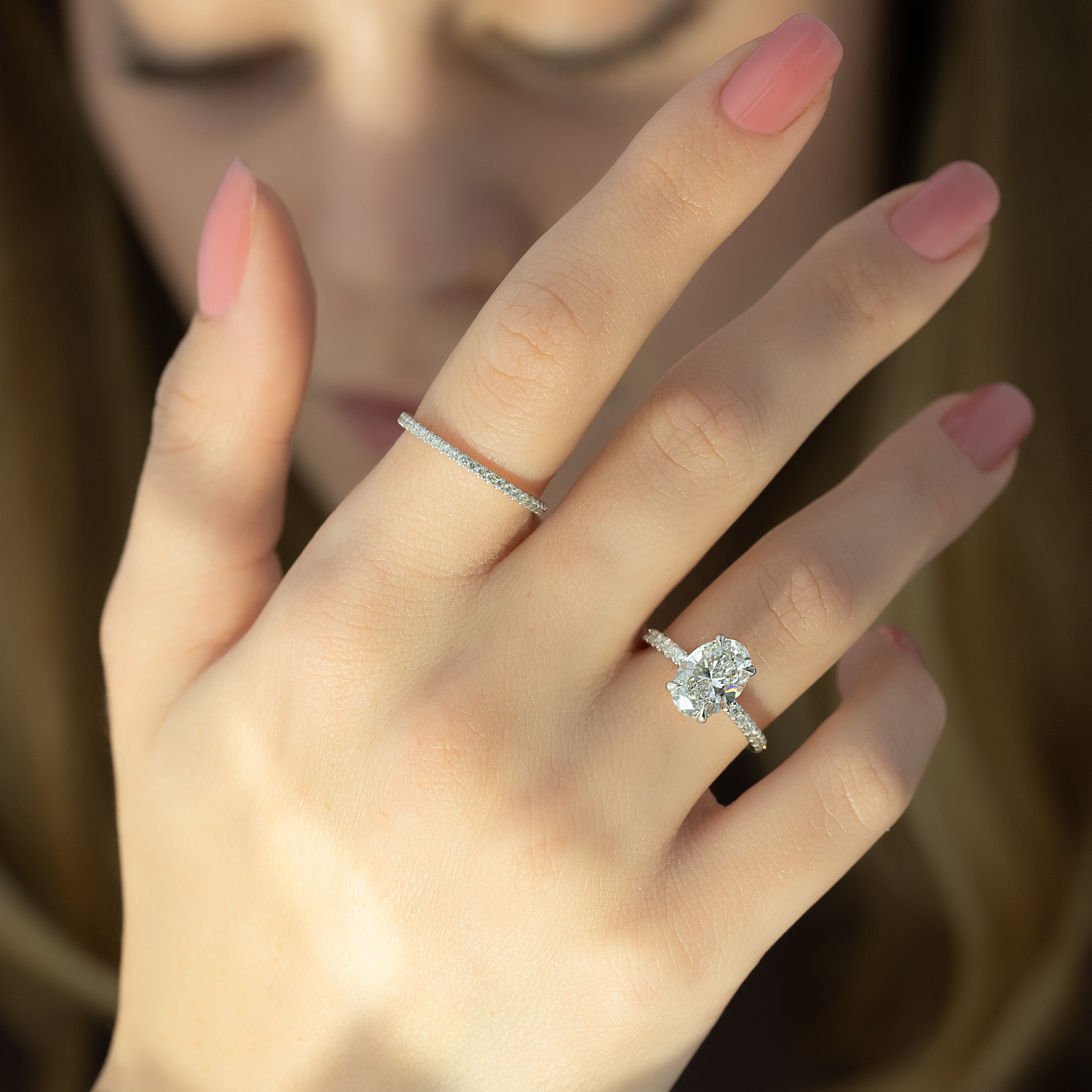 Oval cut CVD diamond engagement ring featuring hidden halo and pave band in platinum
