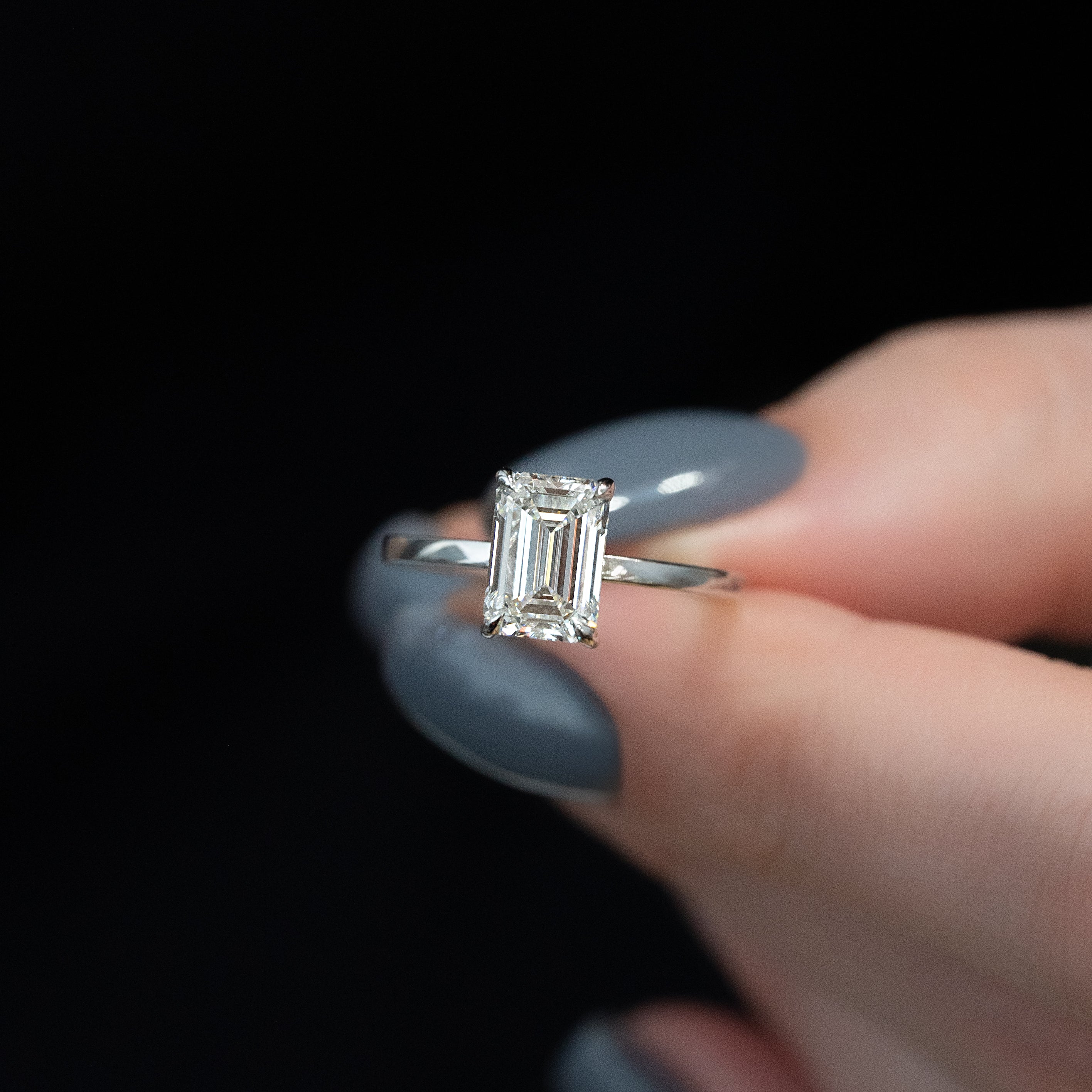 Emerald cut moissanite solitaire engagement ring in platinum setting