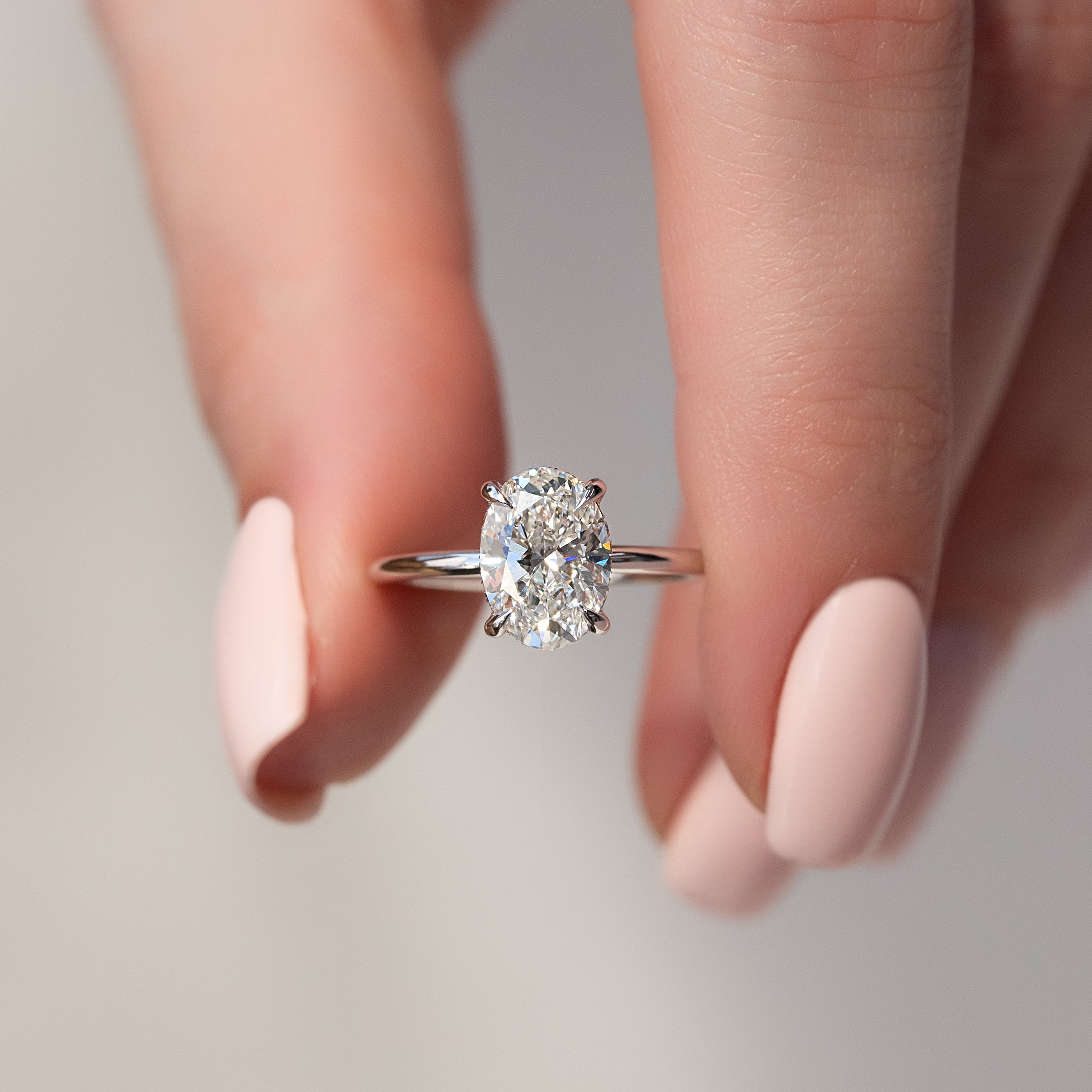 Oval cut CVD diamond hidden halo engagement ring with delicate band in white gold