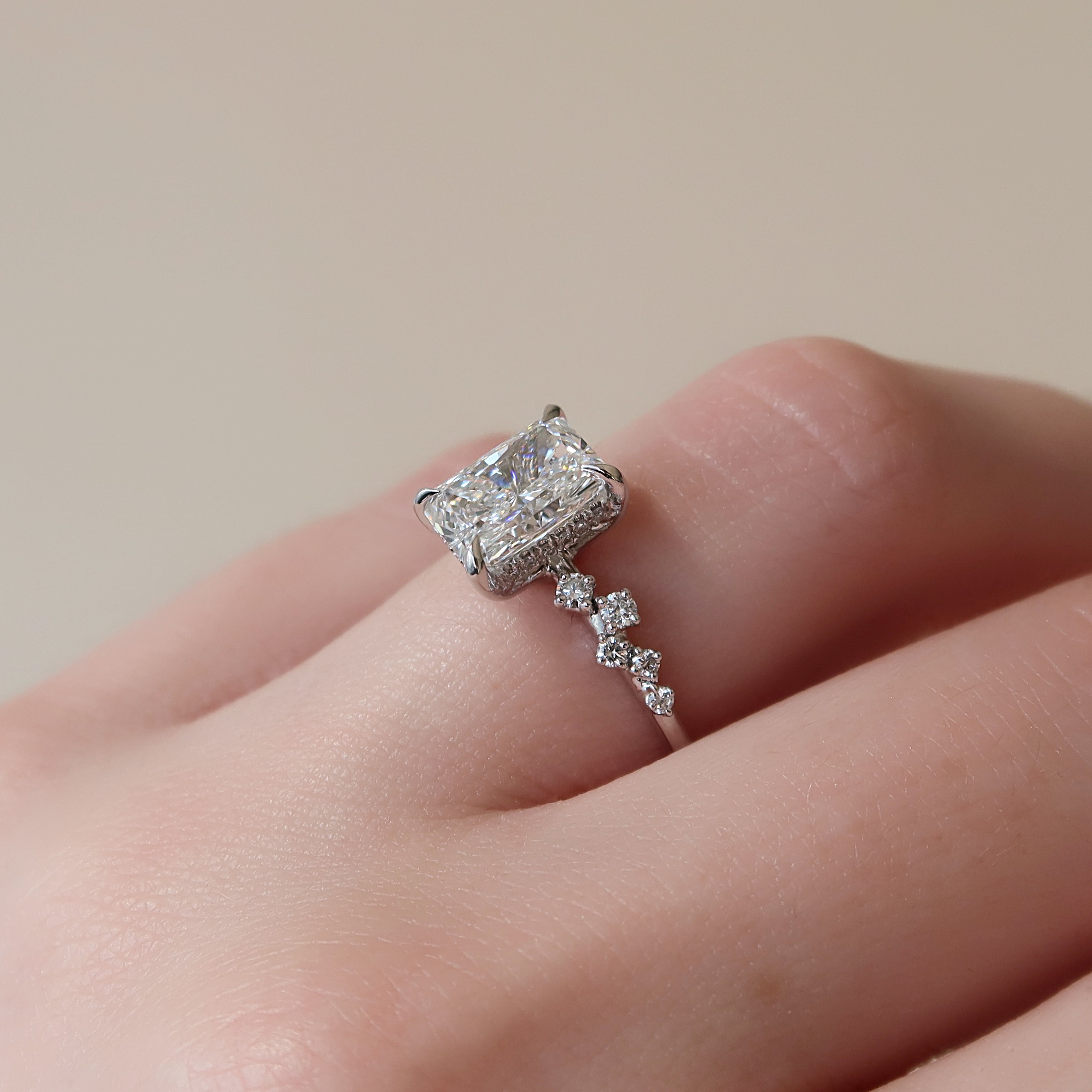 Radiant cut CVD diamond engagement ring with hidden halo and clustered diamond detailing in white gold