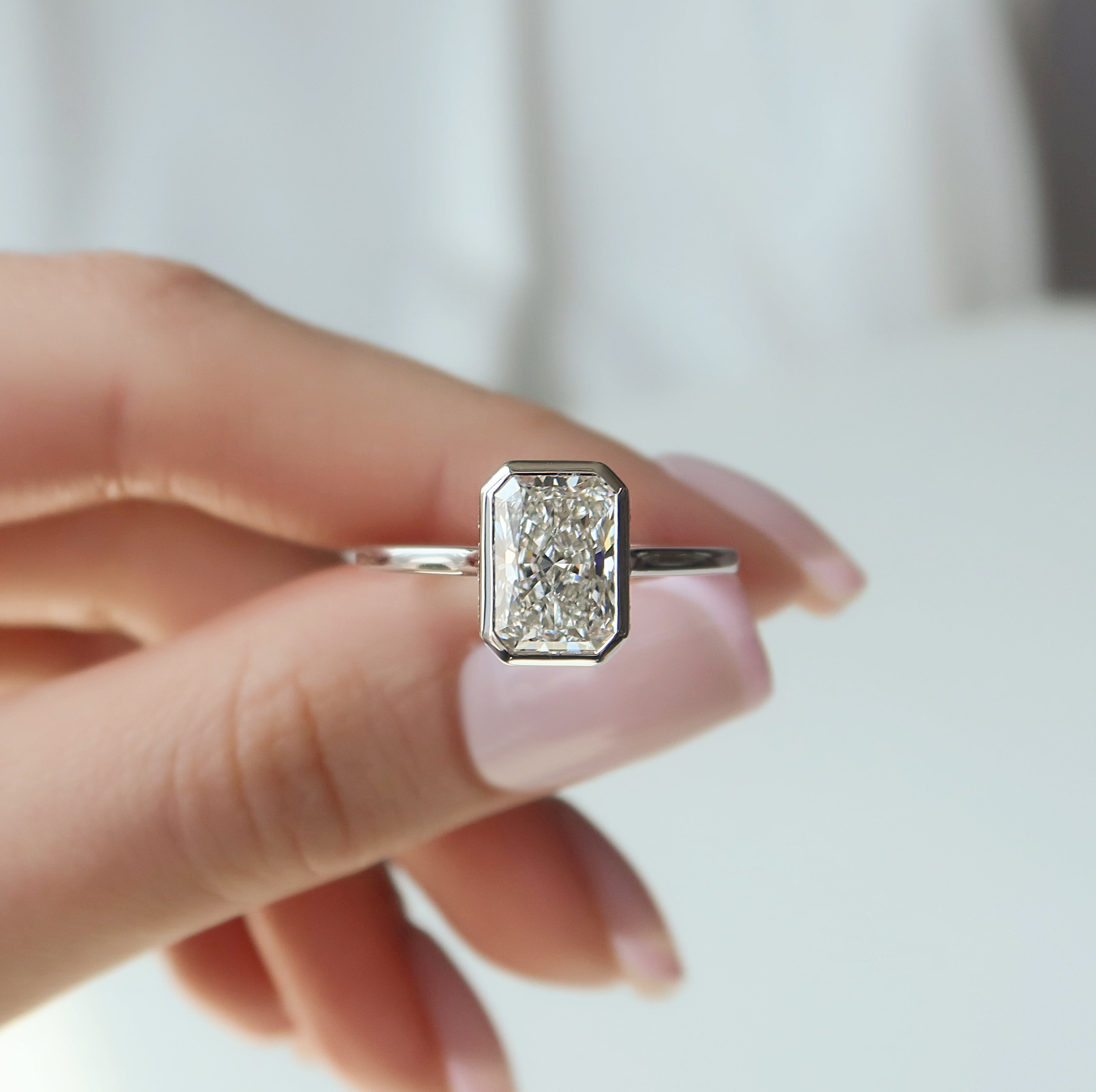 Radiant cut CVD diamond bezel set engagement ring with hidden halo in platinum setting