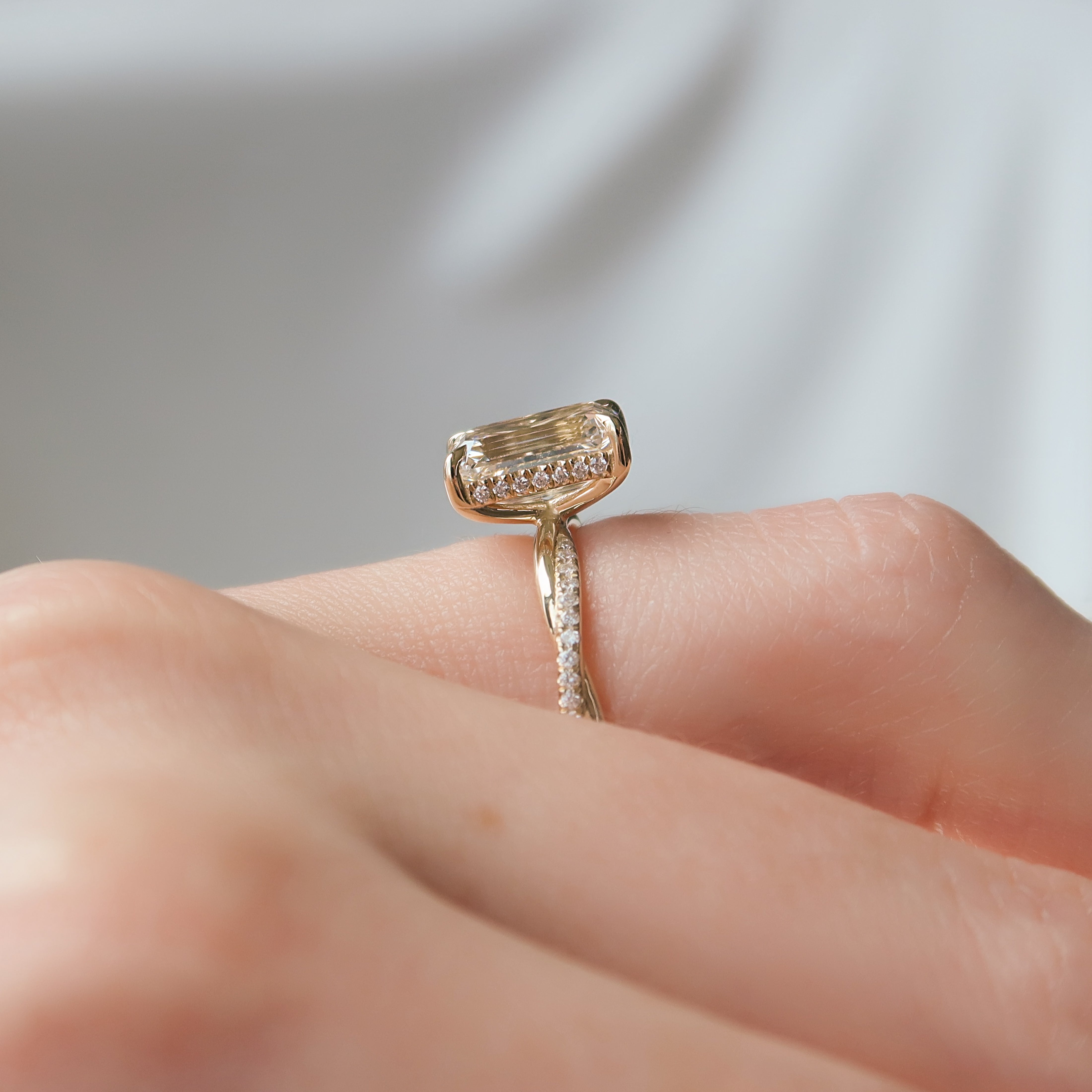 Emerald cut CVD diamond engagement ring with hidden halo and pave diamond band in platinum setting