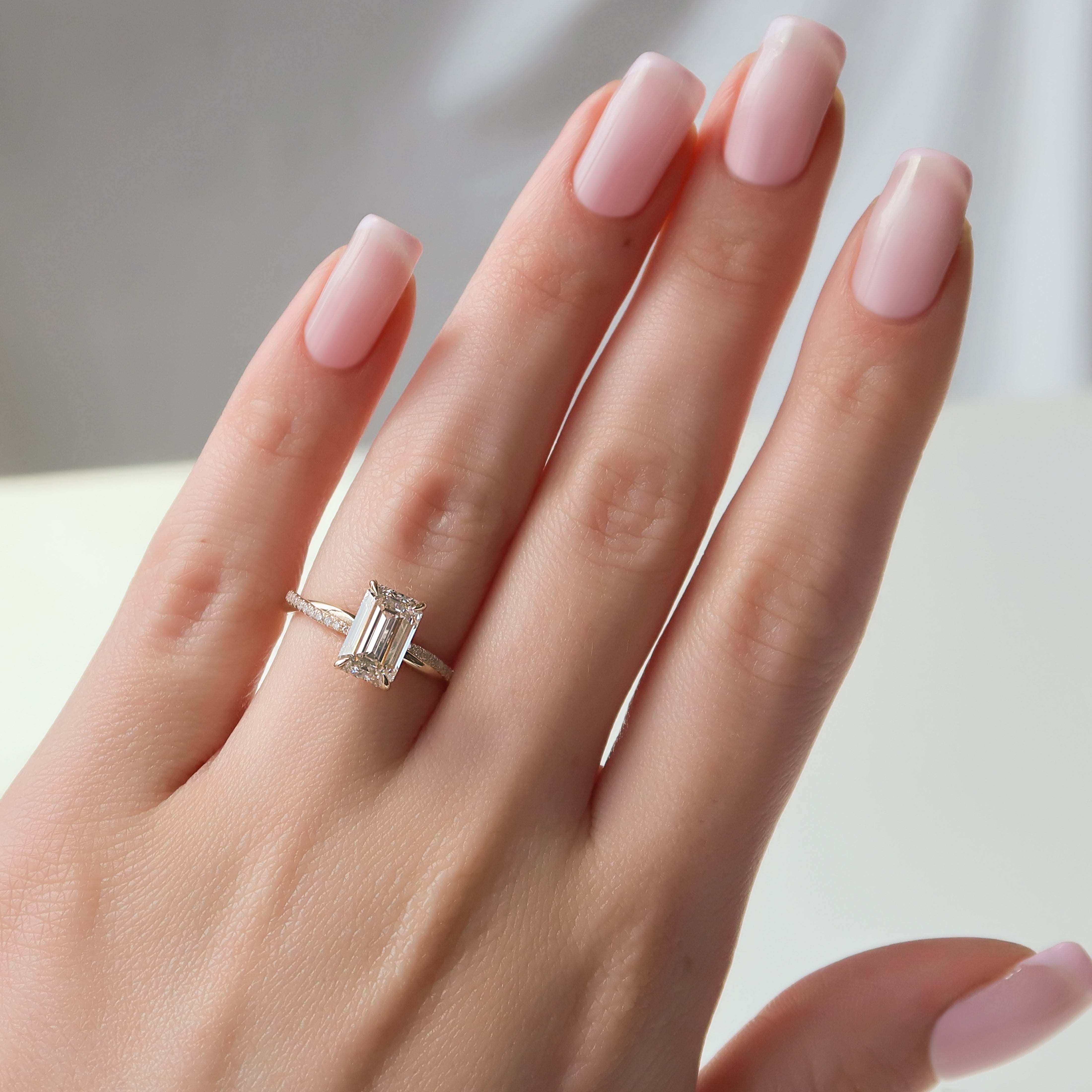 Emerald cut CVD diamond engagement ring with hidden halo and pave diamond band in platinum setting