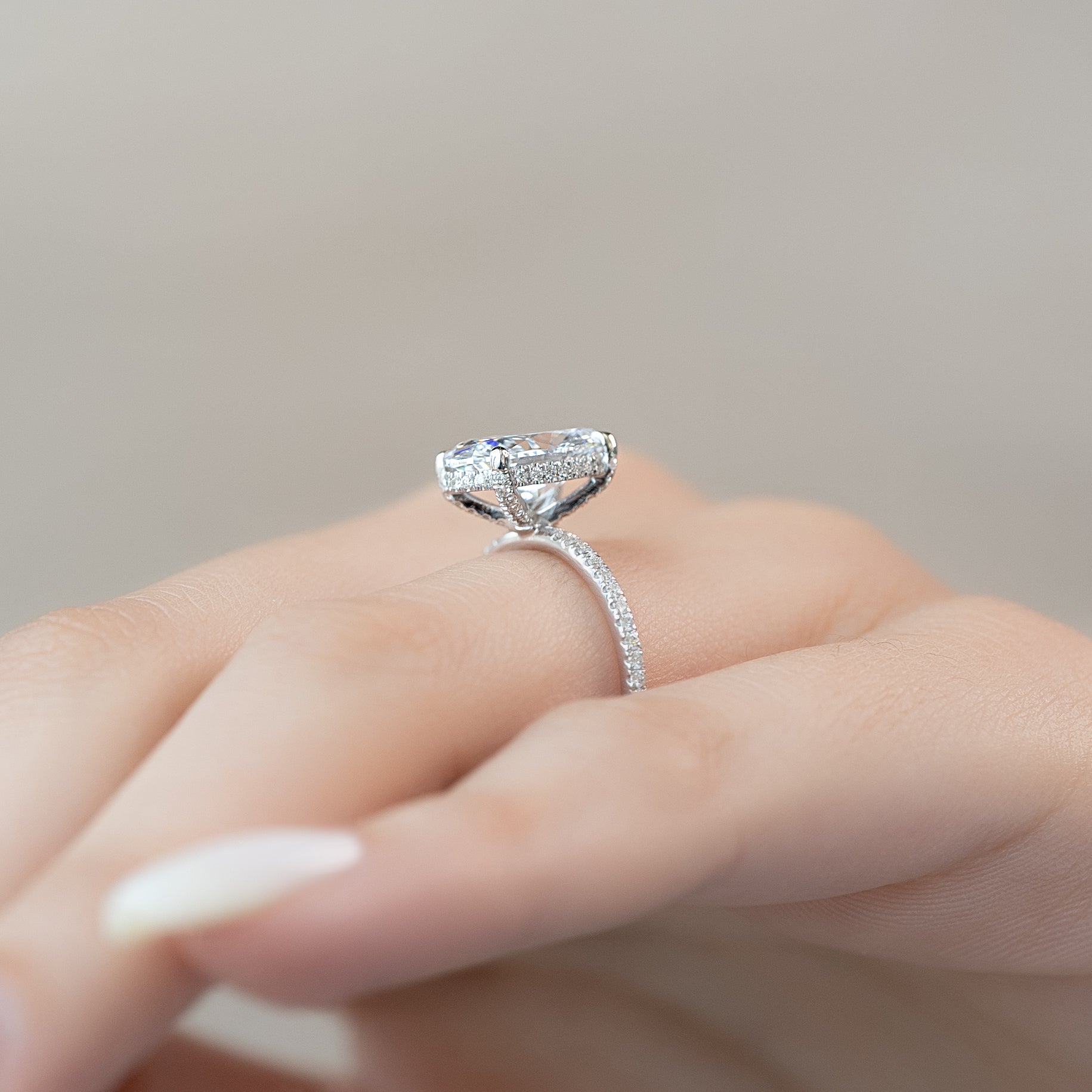 Oval cut CVD diamond engagement ring featuring hidden halo and pave band in platinum