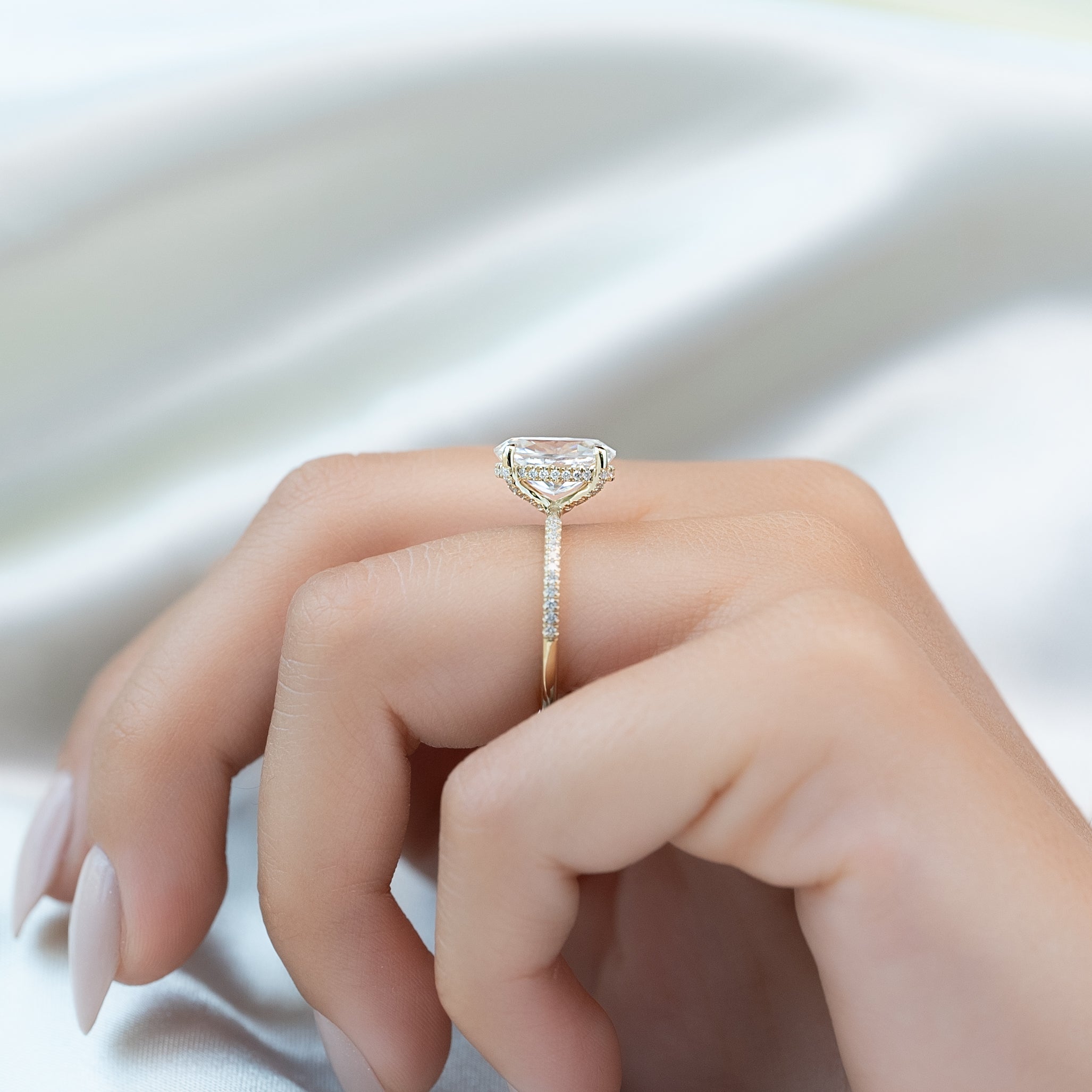 Oval cut CVD diamond engagement ring featuring hidden halo and pave band in platinum