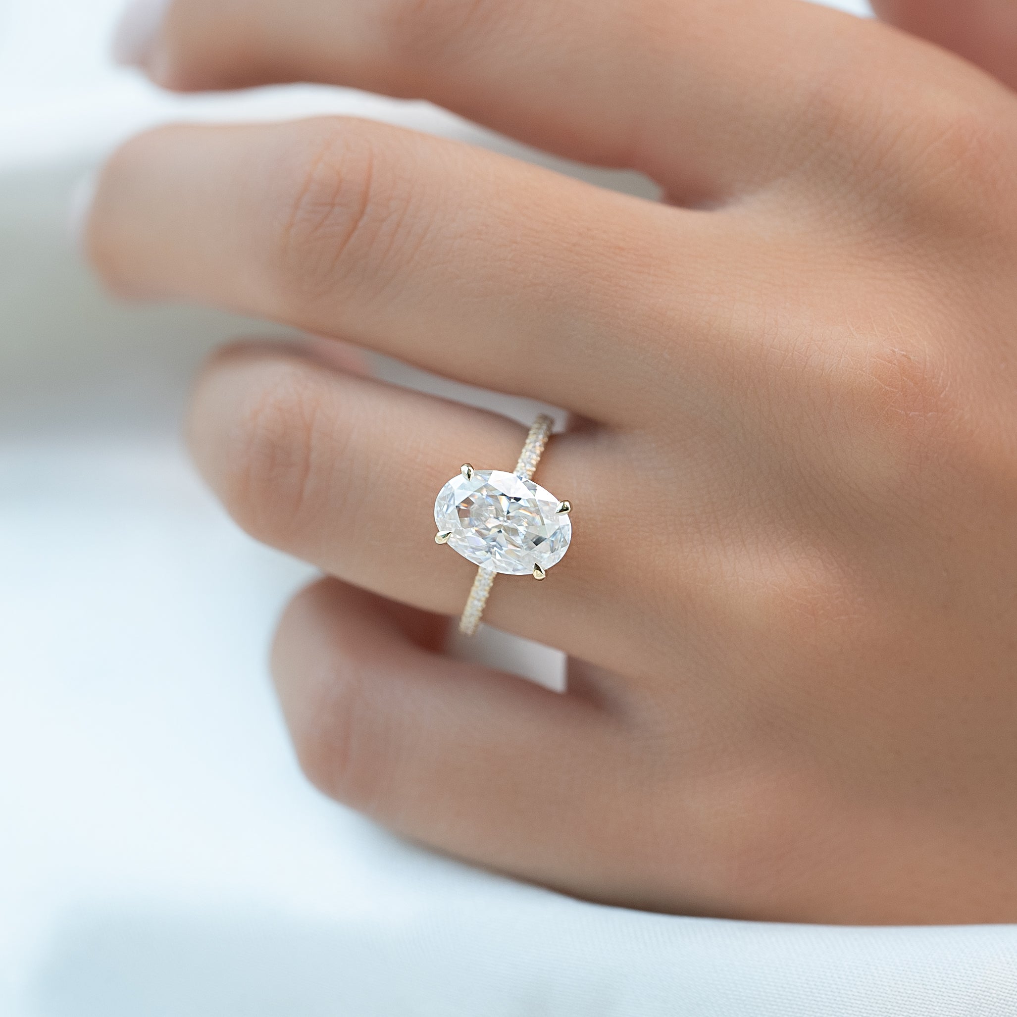 Oval cut CVD diamond engagement ring featuring hidden halo and pave band in platinum