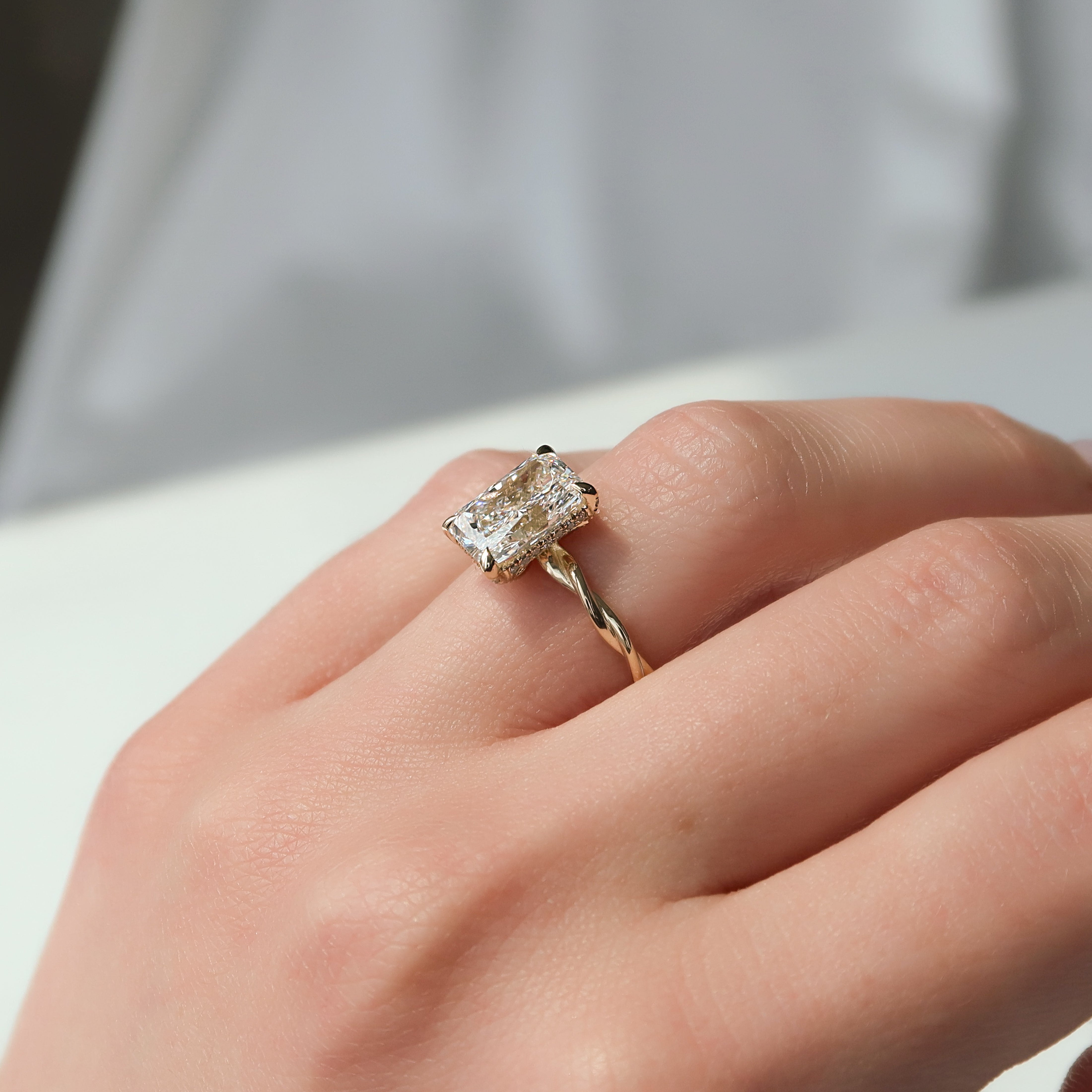 Radiant cut CVD diamond twisted hidden halo engagement ring in white gold setting