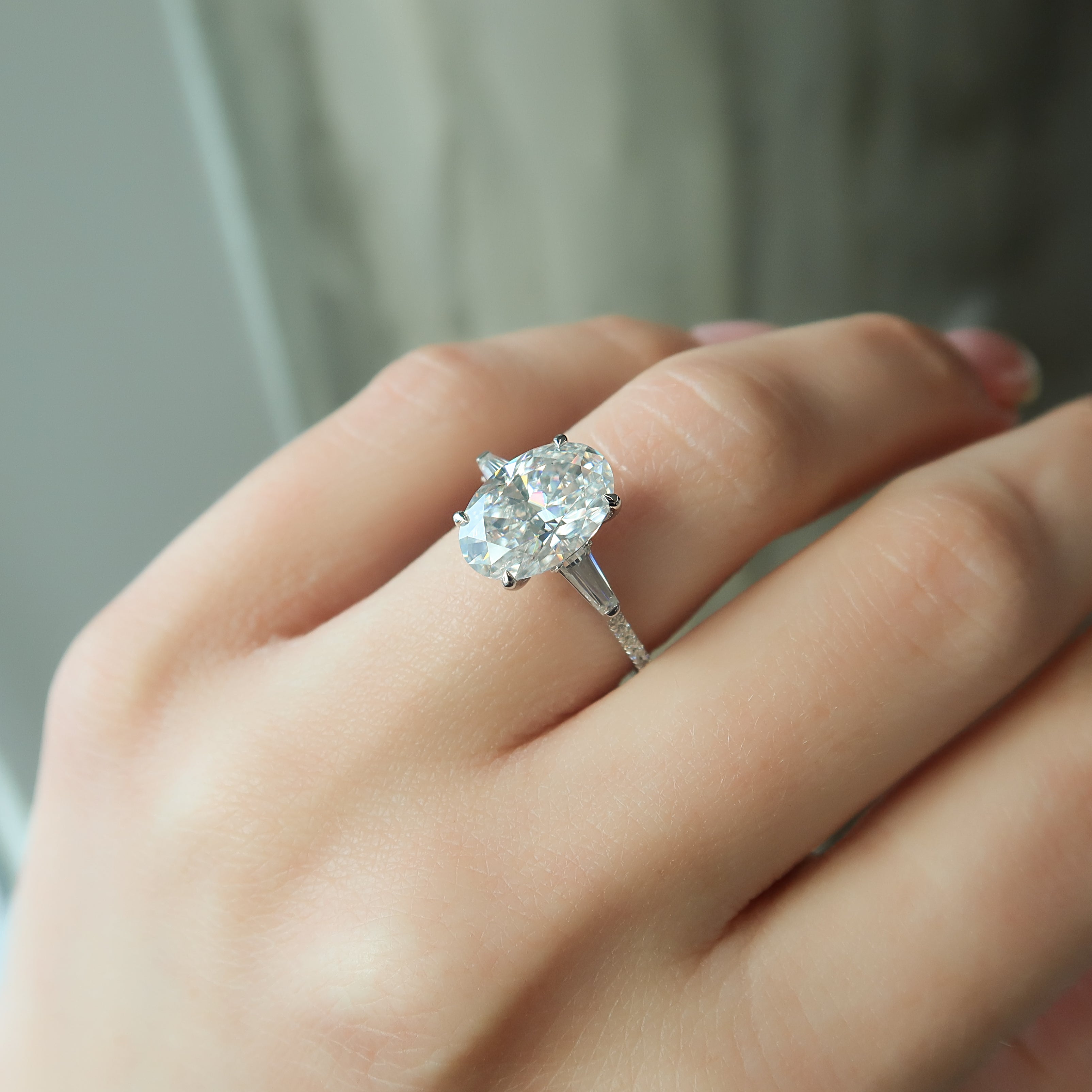Oval cut CVD diamond three stone engagement ring with side stones in white gold