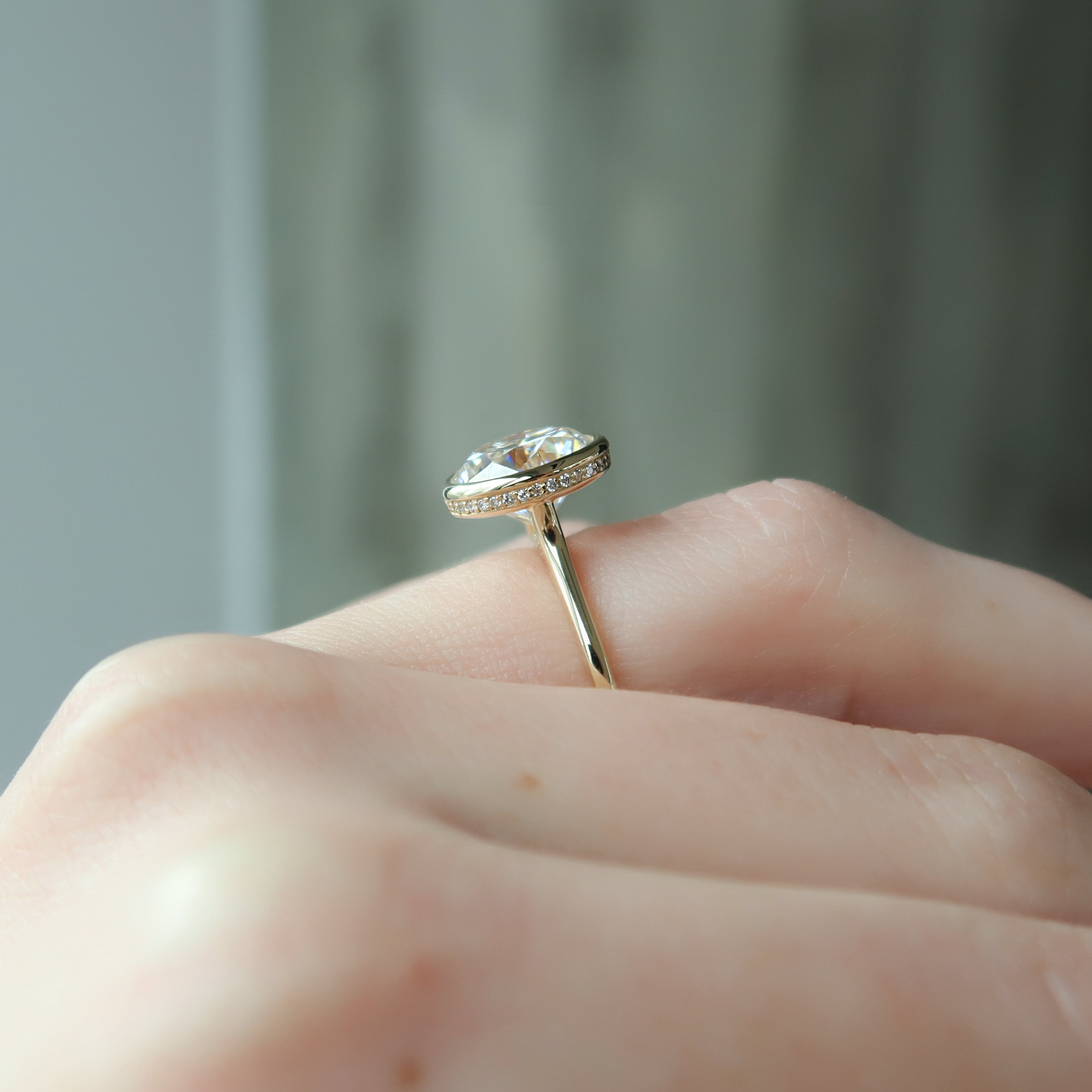 Round cut CVD diamond engagement ring with hidden halo and bezel setting in white gold