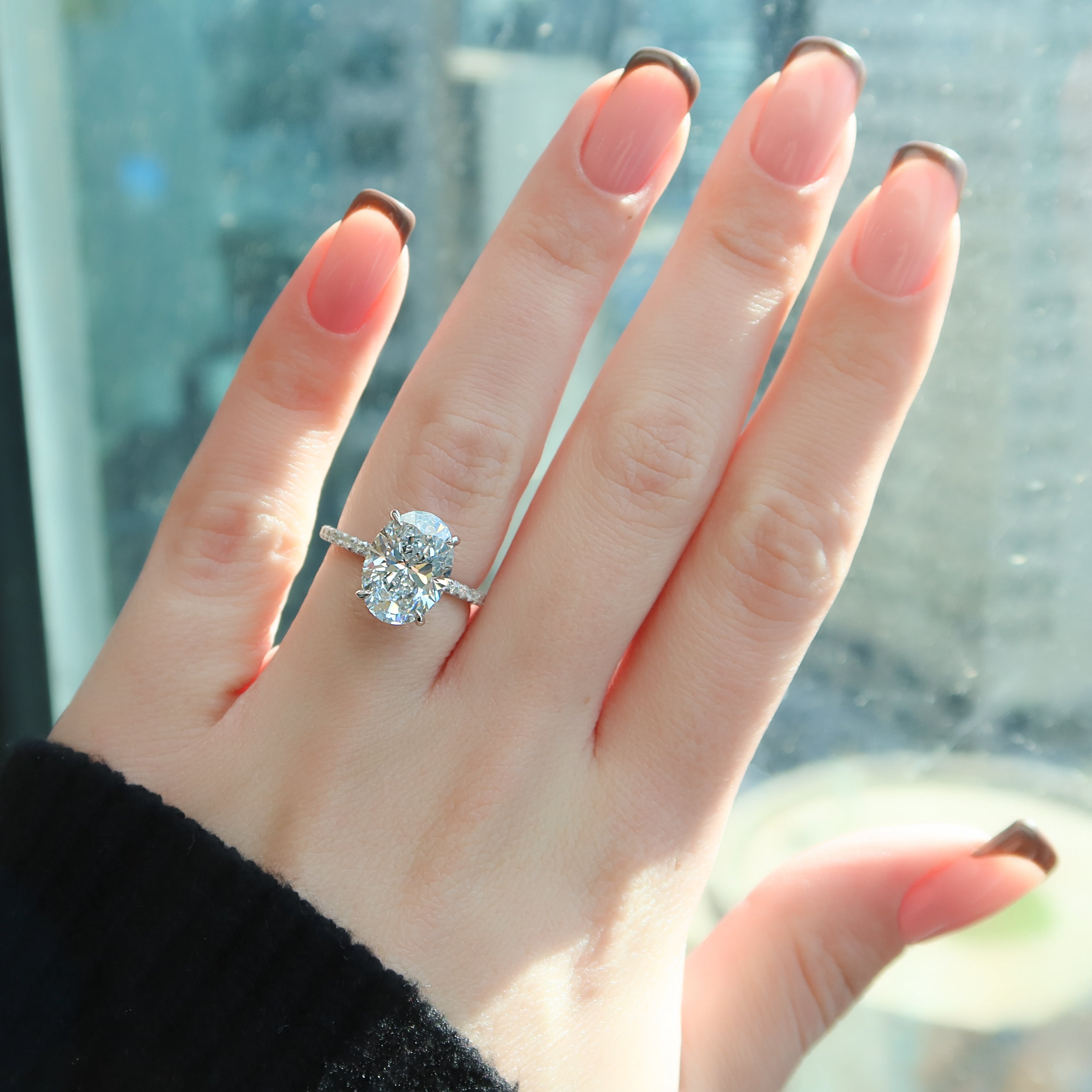 Oval cut CVD diamond engagement ring featuring hidden halo and pave band in platinum