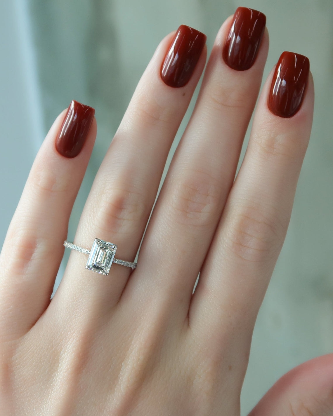 Emerald cut moissanite engagement ring with pave diamond band in white gold setting