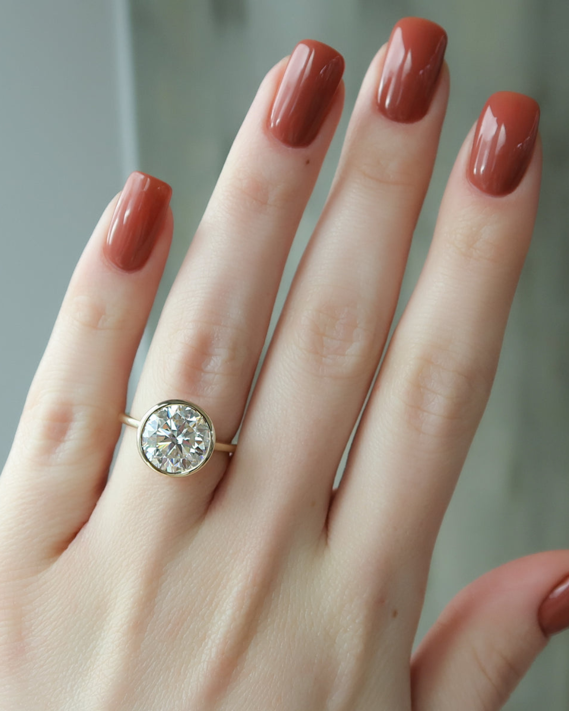 Round cut CVD diamond engagement ring with hidden halo and bezel setting in white gold