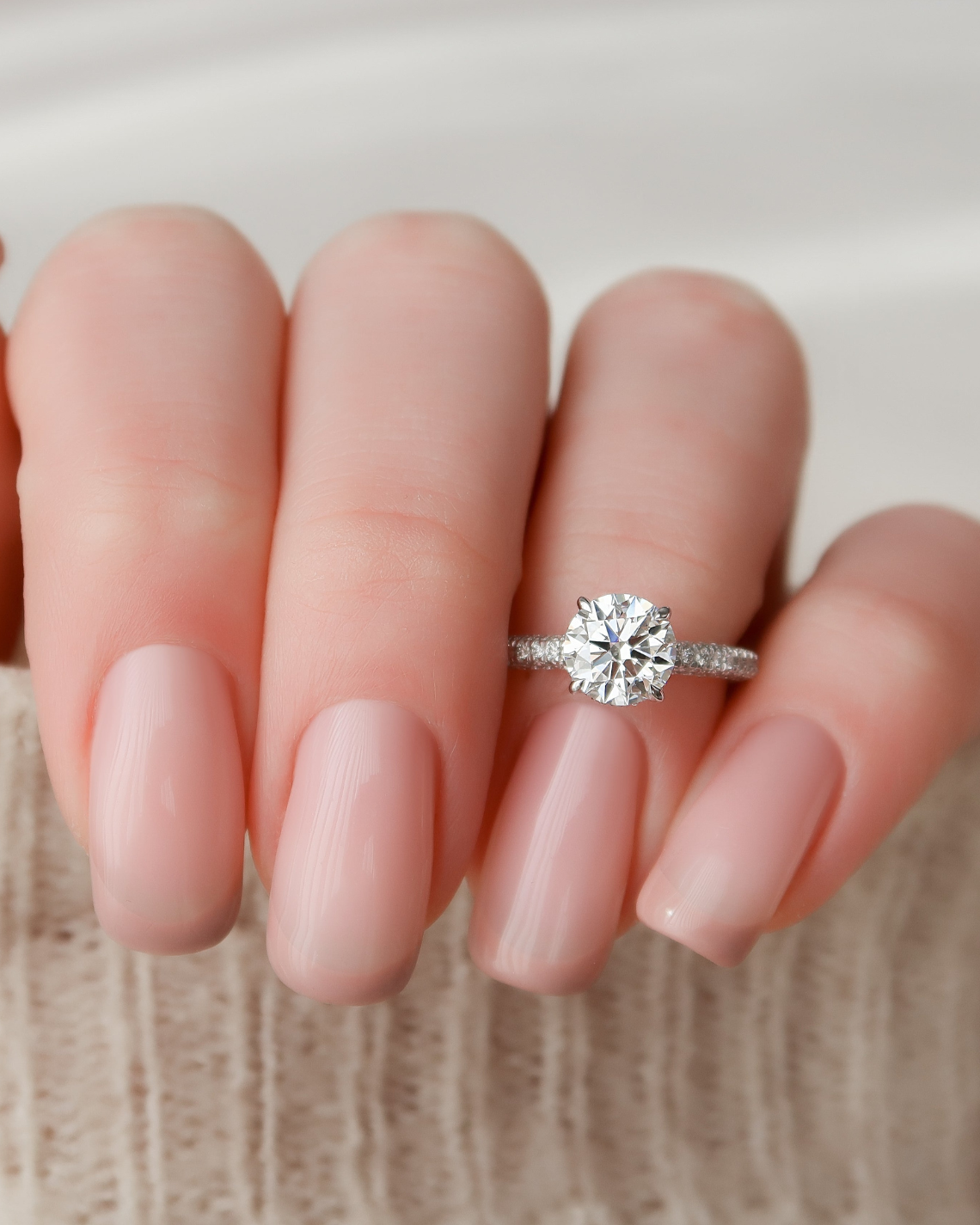 Round cut moissanite engagement ring with hidden halo and pave band in white gold setting