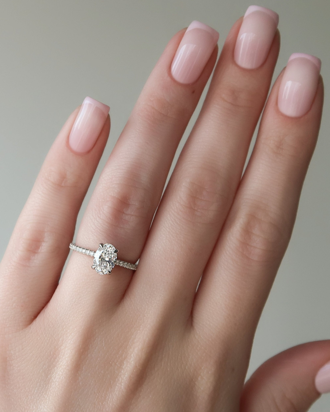 Oval cut CVD diamond engagement ring featuring hidden halo and pave band in platinum