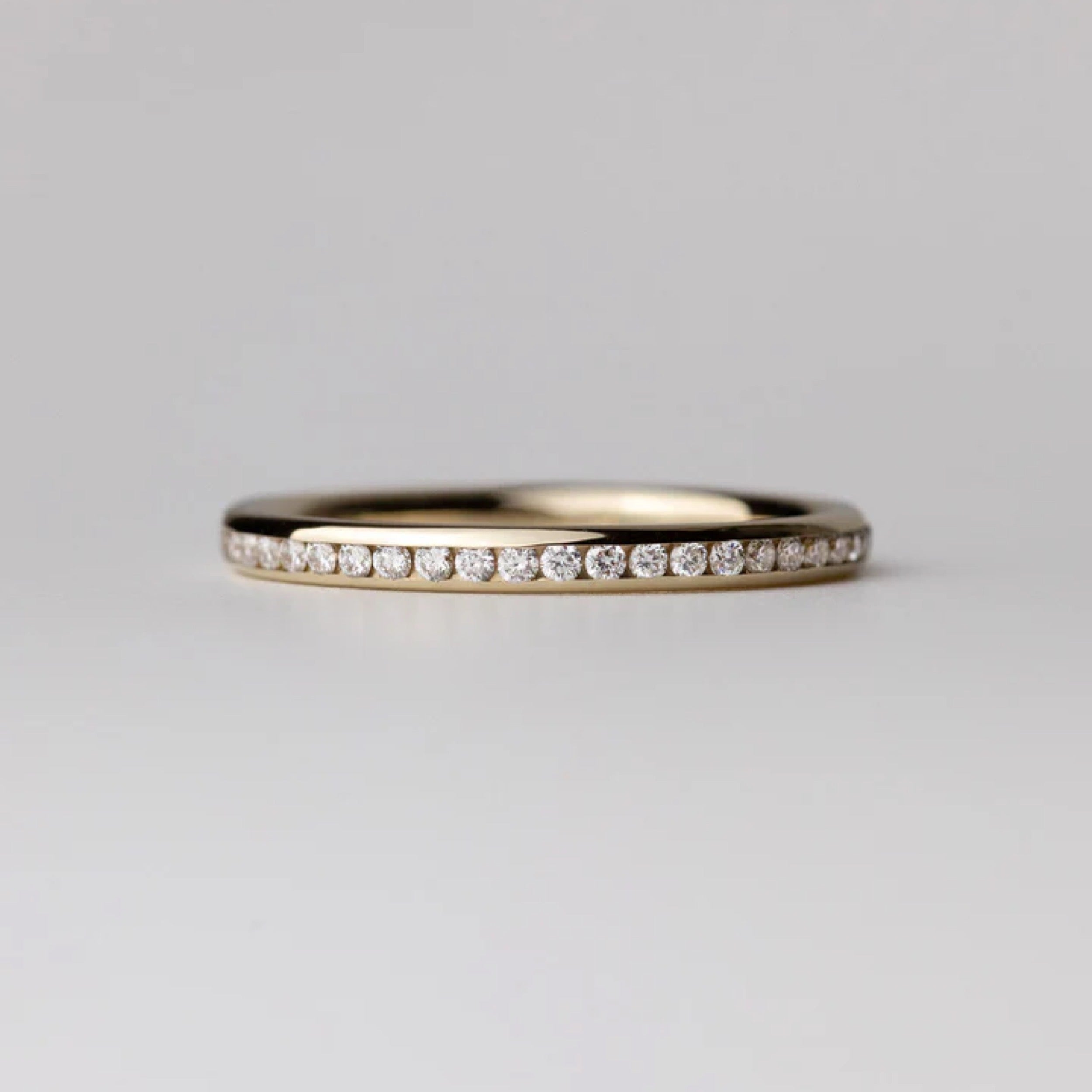0.35 TCW round cut diamond wedding band featuring CVD lab grown diamonds set in a simple curved gold band.