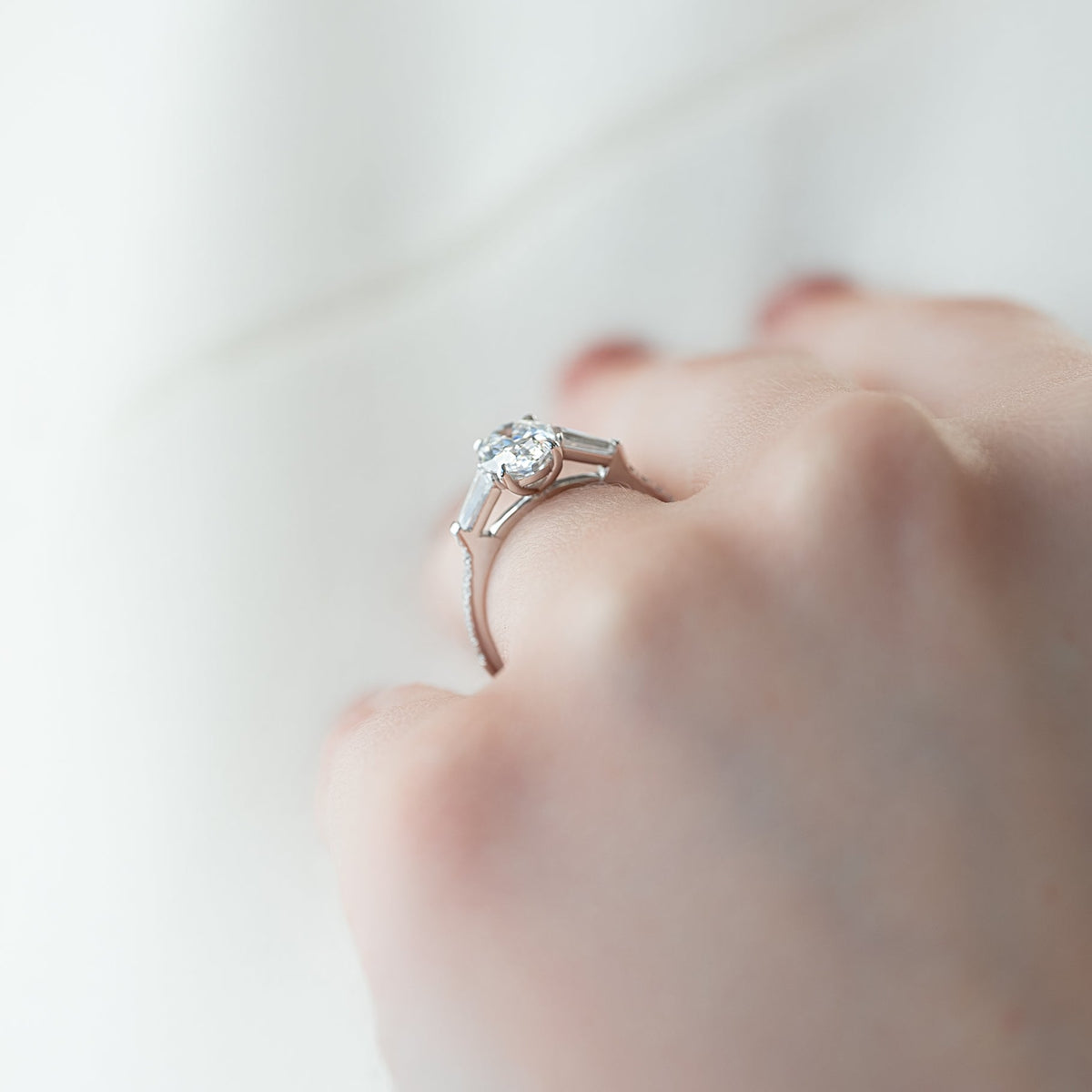 Oval cut CVD diamond three stone engagement ring with side stones in white gold
