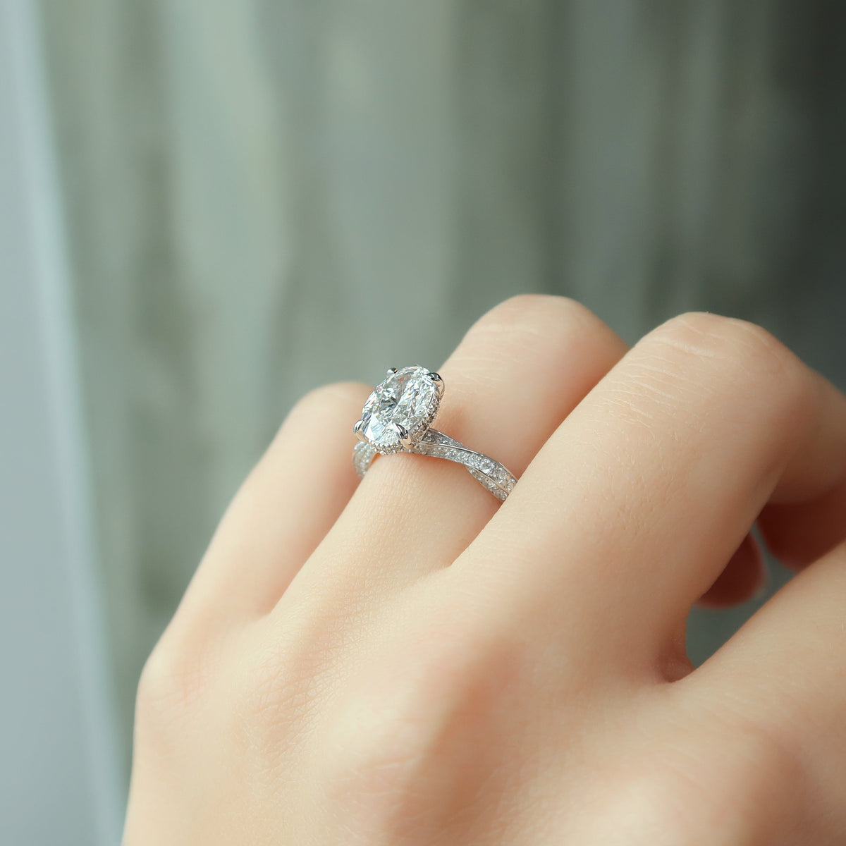 Oval cut CVD diamond engagement ring with twisted band and hidden halo setting
