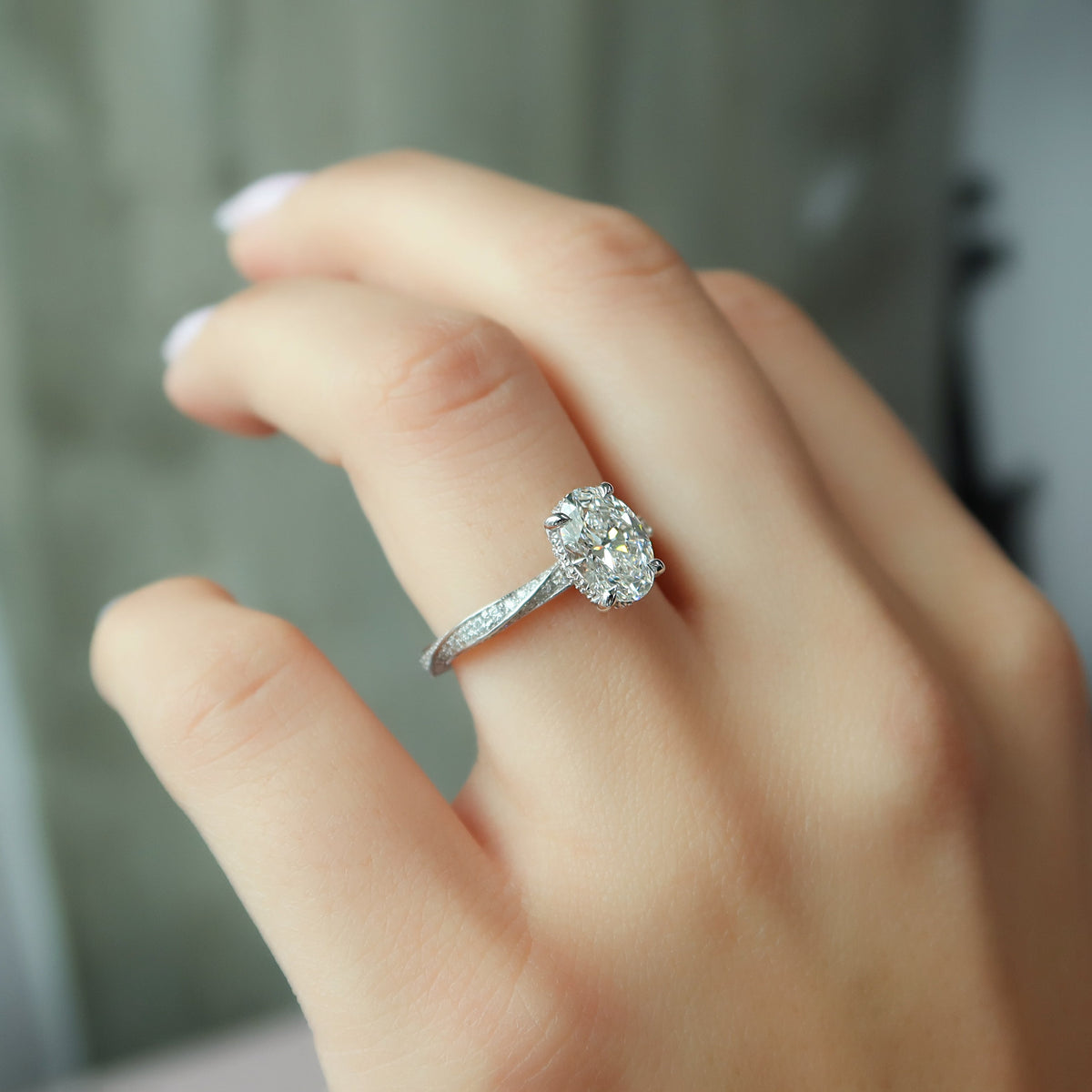 Oval cut CVD diamond engagement ring with twisted band and hidden halo setting