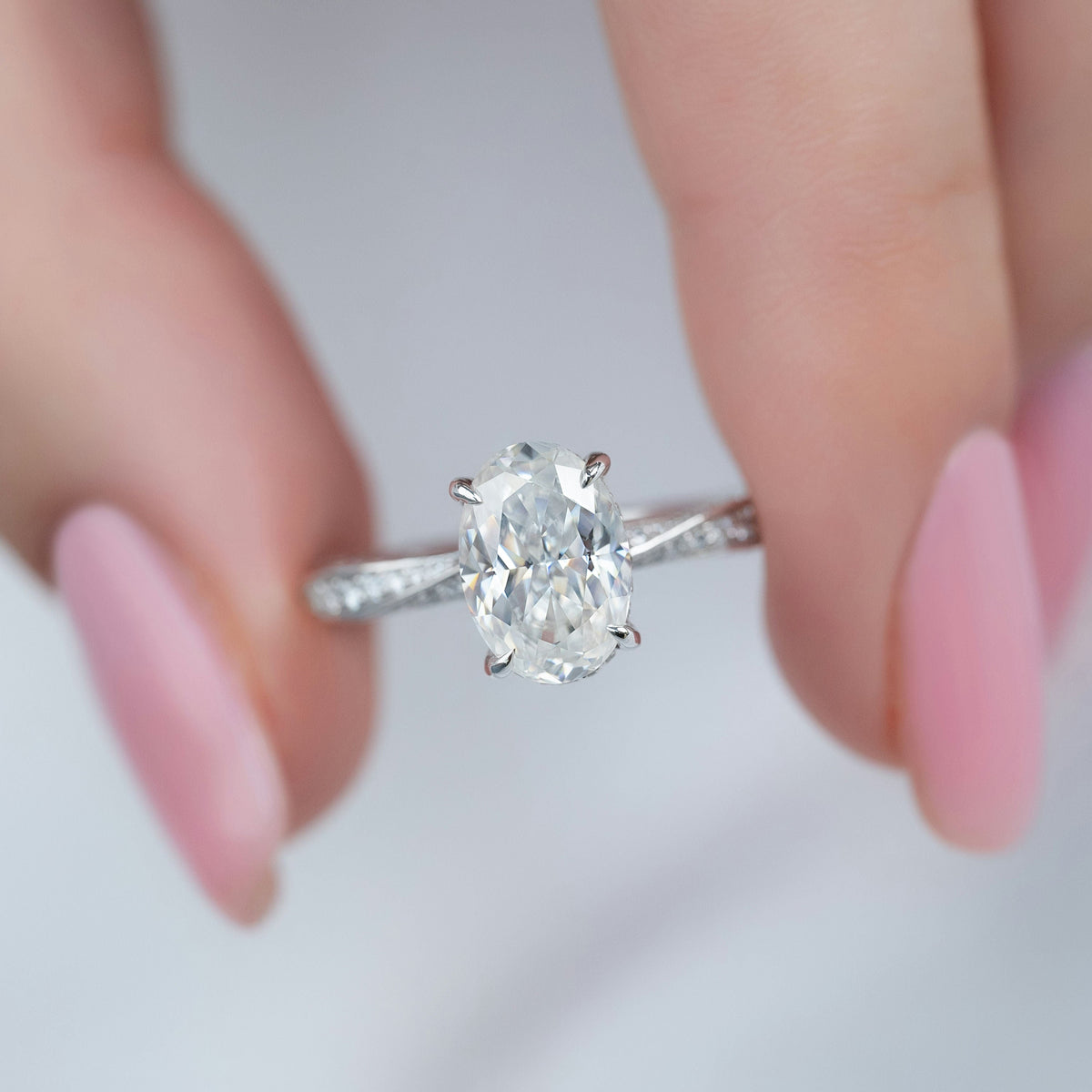 Oval cut CVD diamond engagement ring with twisted band and hidden halo setting