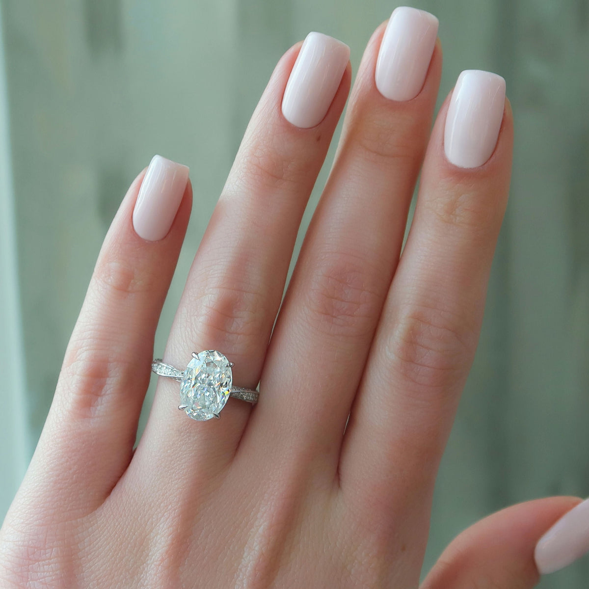 Oval cut CVD diamond engagement ring with twisted band and hidden halo setting