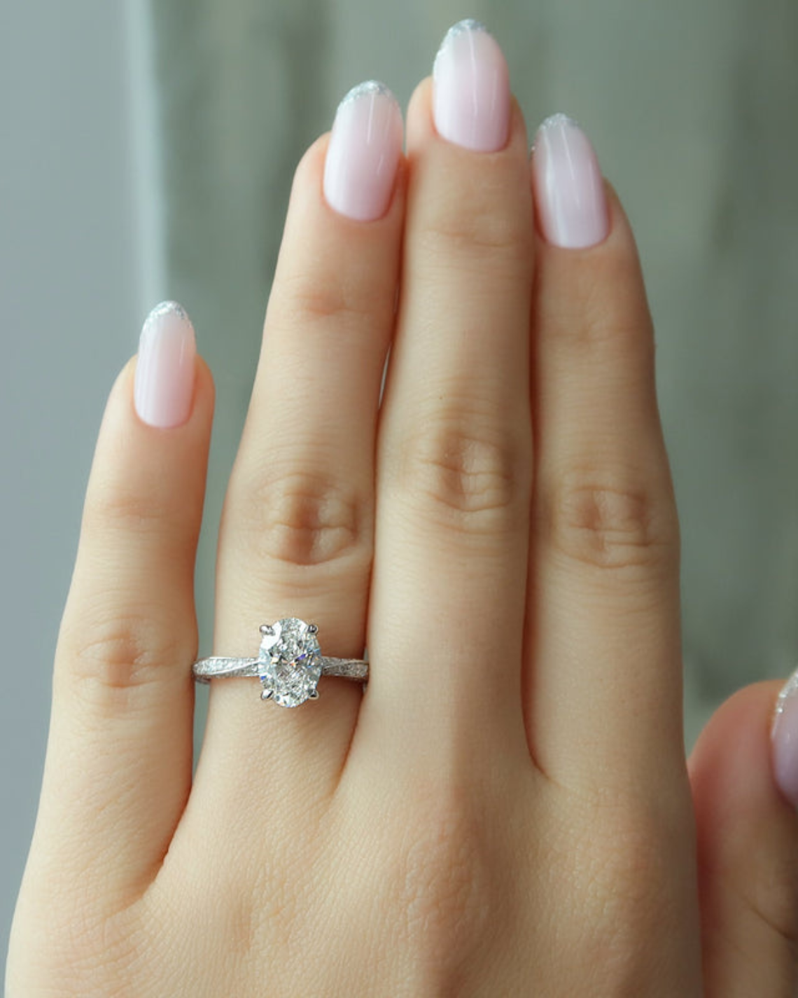 Oval cut CVD diamond engagement ring with twisted band and hidden halo setting