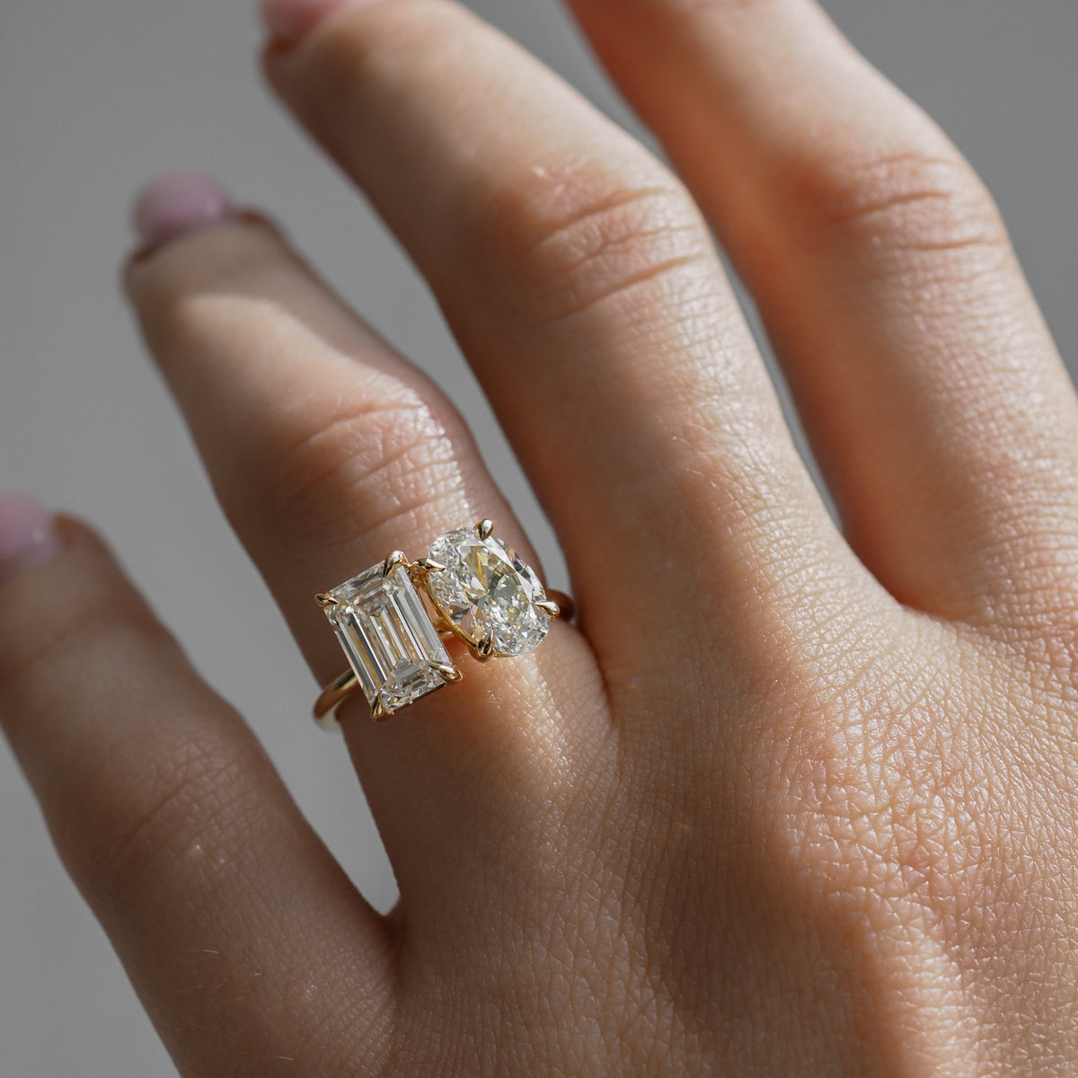 3.6 carat emerald and oval cut moissanite two-stone engagement ring in white gold setting

